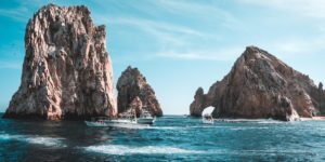 photo-of-boats-on-ocean-near-rock-formations-3271898